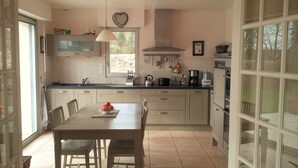 Une cuisine équipée d’une table à manger, de chaises et de divers appareils de cuisine.