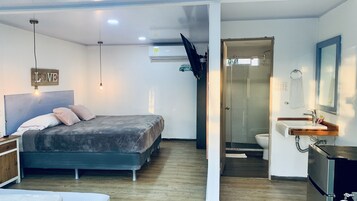 Un dormitorio con cama, mesita de noche y lámpara de pared.