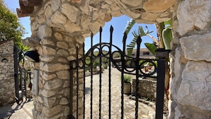A stone archway leading to a courtyard with a wrought iron gate.