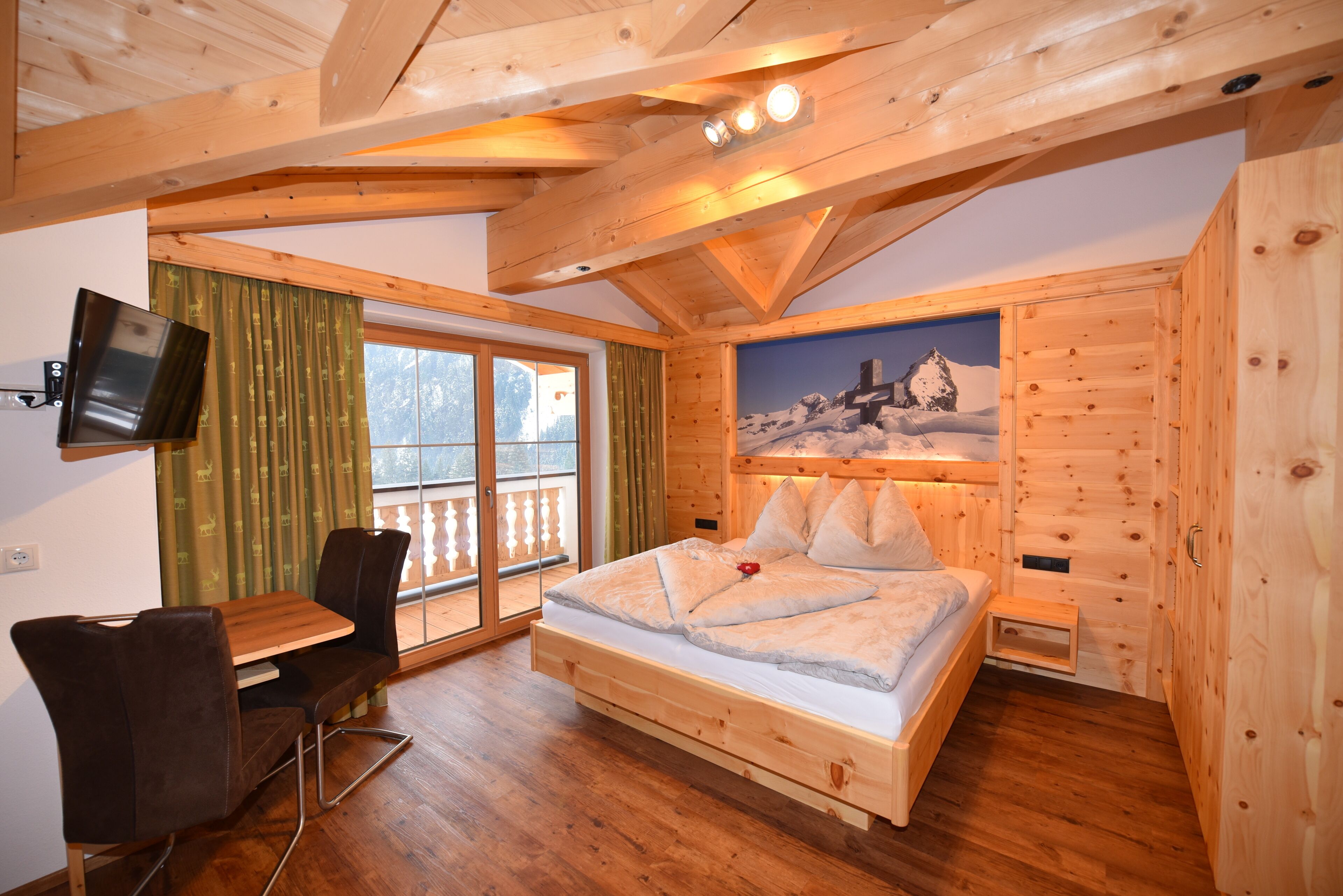 A wooden cabin bedroom with a bed, a desk, and a chair.