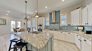 A spacious kitchen with a large island, white cabinetry, and granite countertops. - "Holiday House" 3BR/2.5 Bath at Prominence (Santa Rosa Beach)
