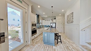 A modern kitchen with a central island, built-in appliances, and a view to the outside. - "Holiday House" 3BR/2.5 Bath at Prominence (Santa Rosa Beach)
