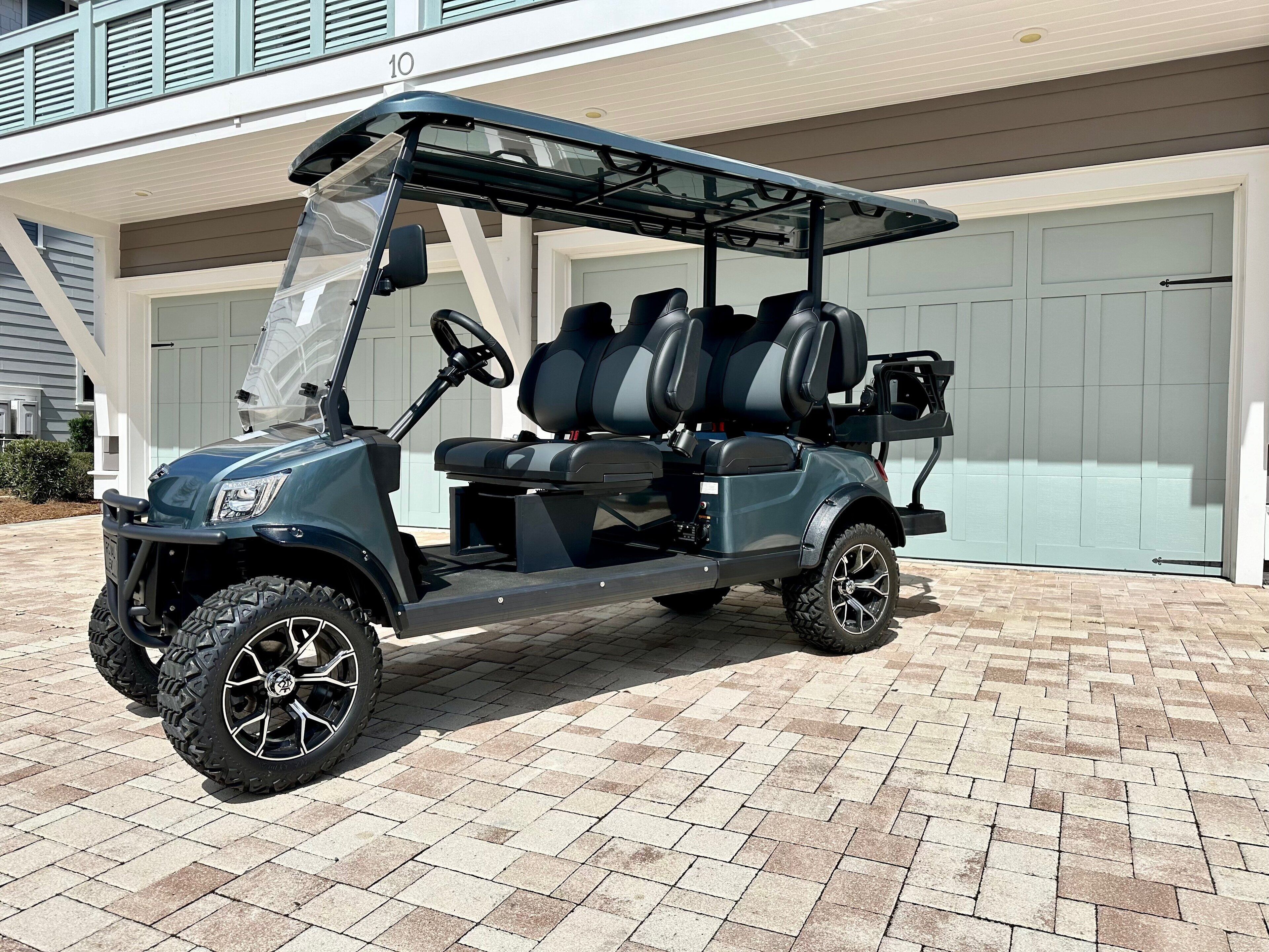 Un golf cart parcheggiato di fronte a un edificio con un garage.