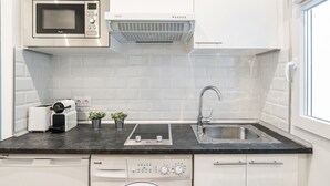 Une cuisine moderne équipée d’un four à micro-ondes, d’un grille-pain, d’un évier et d’un lave-vaisselle.