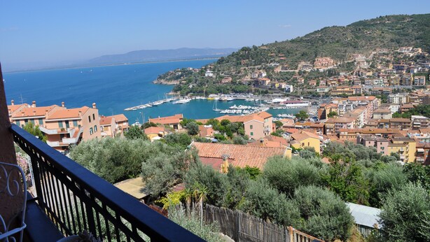 A coastal town with buildings, a marina, and a view of the sea.