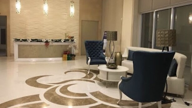 A modern lobby with a reception desk, seating area, and a patterned floor. - Modern - Studio Unit Near NAIA3 (Pasay)