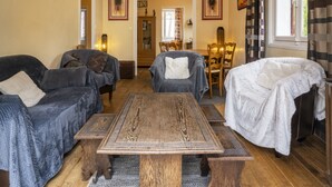En hyggelig stue med to sofaer, et træbord og en lænestol.