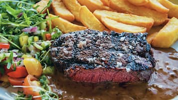 A plate with a steak, fries, and a salad.