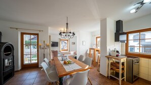 A modern kitchen with a dining area, a built-in oven, and a window with a view. - Time by the Lake. Wildrose Duplex – Fireplace, Loggia, View of the Greenery (Bad Saarow)