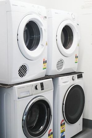 Two stacked front-loading washing machines with energy efficiency labels. - Stay Motel (Gympie)