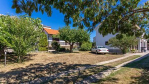 A residential area with houses, a white car, and trees. - Beach front apartment in Jurandvor (Jurandvor)