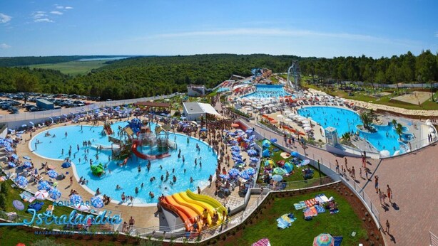 Ein weitläufiger Außenpoolbereich mit mehreren Pools, Wasserrutschen und Liegestühlen.