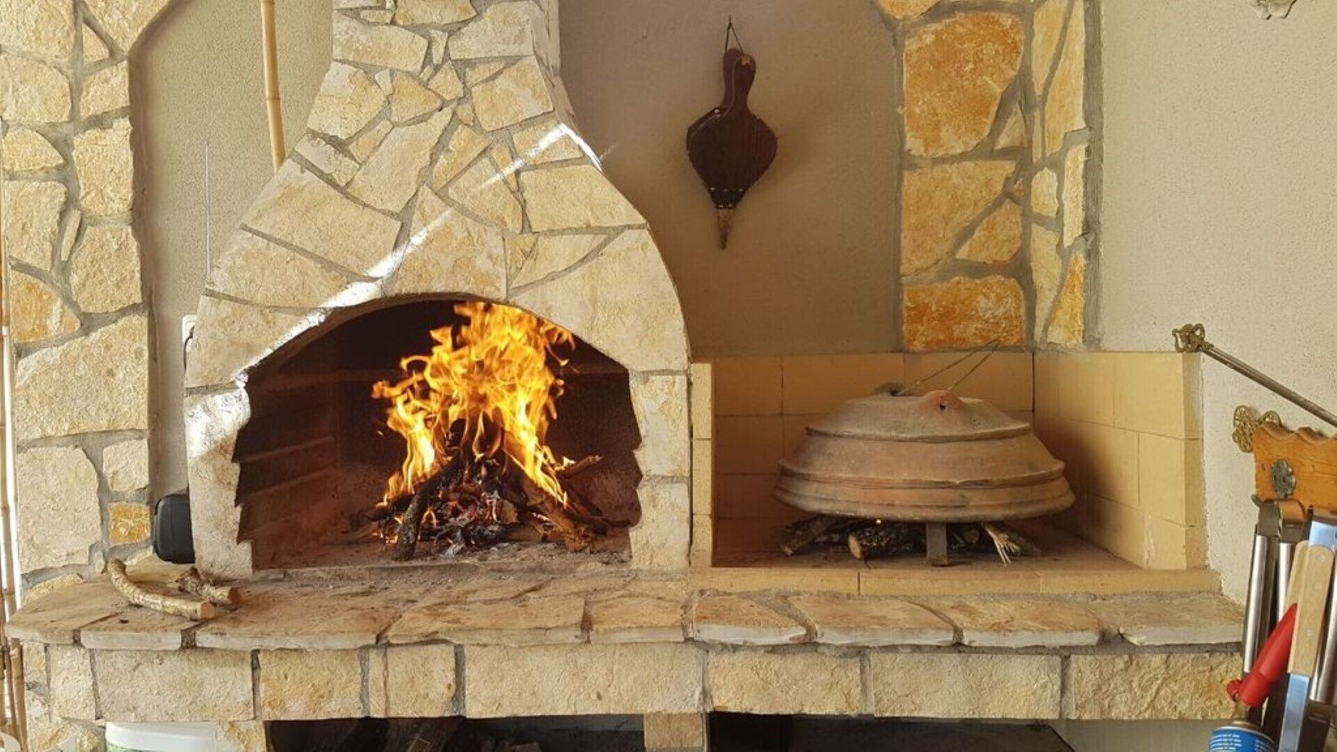 Ein Kamin aus Stein mit brennendem Feuer darin.