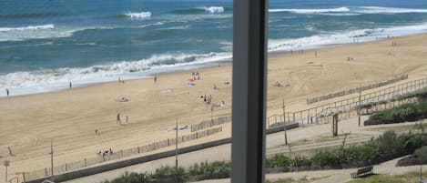 A beach with a wooden boardwalk, a sandy beach, and the ocean.