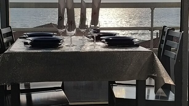 A table set for dining with a view of the sea.
