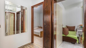 A bedroom with a bed, a nightstand, a mirror, and a door leading to another room. - Awesome apartment in Jurandvor with WiFi (Jurandvor)