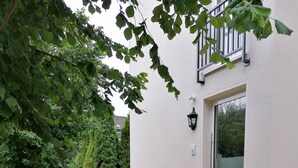 A modern building with a white exterior and a glass door. - Apartment with hotel comfort (Bad Rothenfelde)