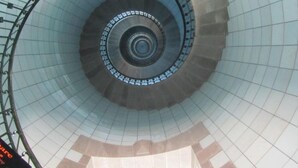 A spiral staircase with a glass enclosure and metal railings.