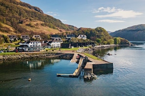 A lakeside village with houses, a dock, and a rocky shoreline. - Waterfront Lodge 4 with Hot Tub (Kentallen Pier)