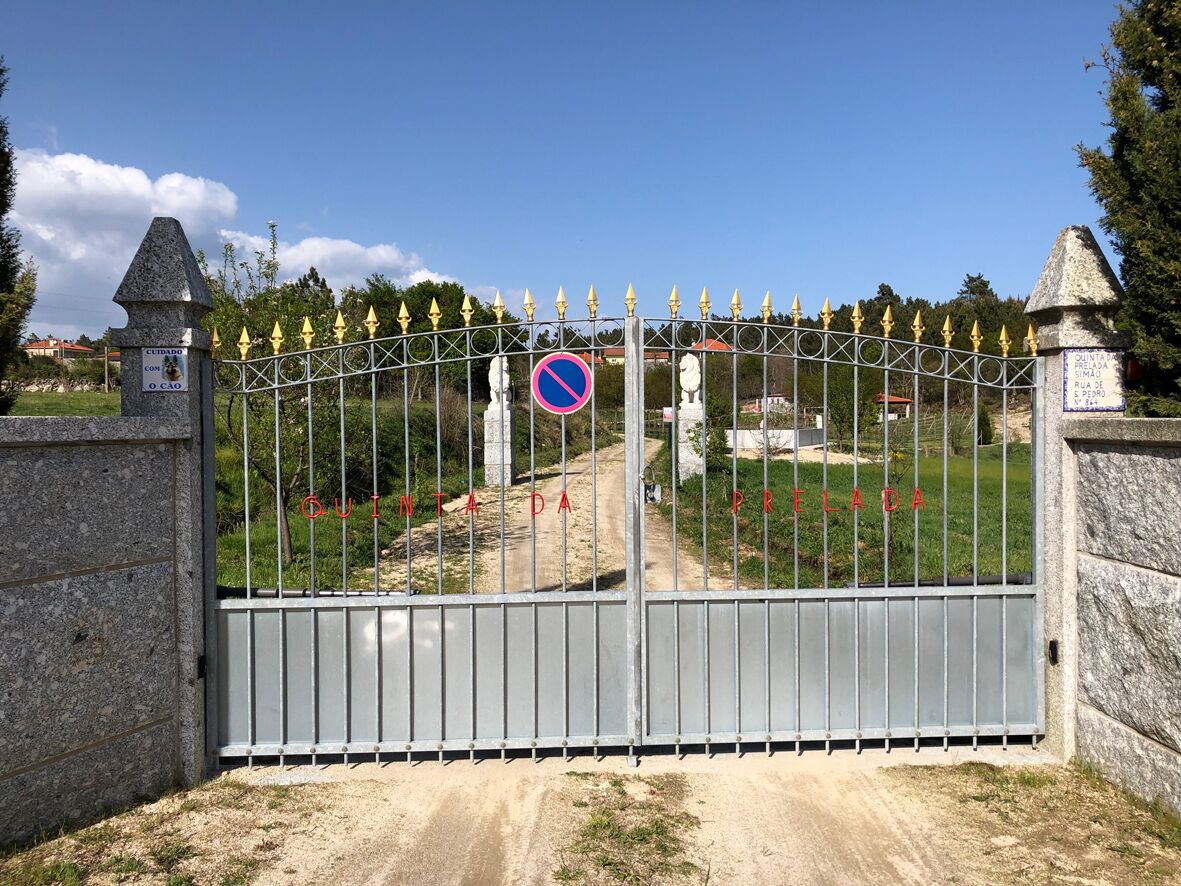 A gated entrance with a no parking sign, a stone monument, and a clear sky.