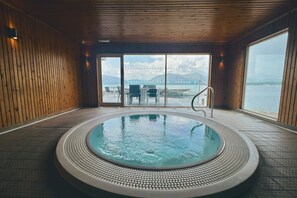 A hot tub with a view of a body of water and mountains in the distance. - Waterfront Lodge 8 with Hot Tub (Kentallen Pier)