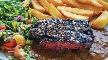 Ein Teller mit einem Steak, Pommes und einem Salat.