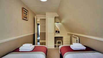 Een hotelkamer met twee bedden, een bureau en een spiegel.
