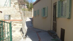 A narrow alleyway with stone walls and a green gate. - House in Taulis Catalan in the hinterland near Perpignan (Taulis)