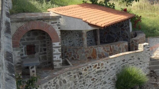 A stone building with a tiled roof, a stone archway, and a small pond. - House in Taulis Catalan in the hinterland near Perpignan (Taulis)