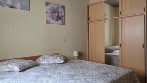 A bedroom with a bed, a wardrobe, a mirror, a lamp, and a floral painting on the wall. - House in Taulis Catalan in the hinterland near Perpignan (Taulis)
