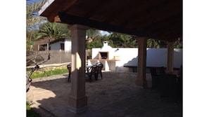 Relax in the shade of a pergola, surrounded by lush greenery, and enjoy a meal prepared on the barbecue grill.