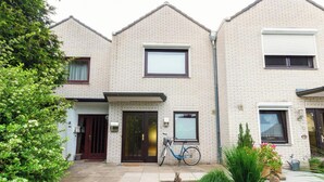 A two-story residential building with a front door, a mailbox, and a bicycle parked outside. - 🌊 Holiday home for 6 in Grömitz | 2 bathrooms, garden & beach chair on the beach (Grömitz)