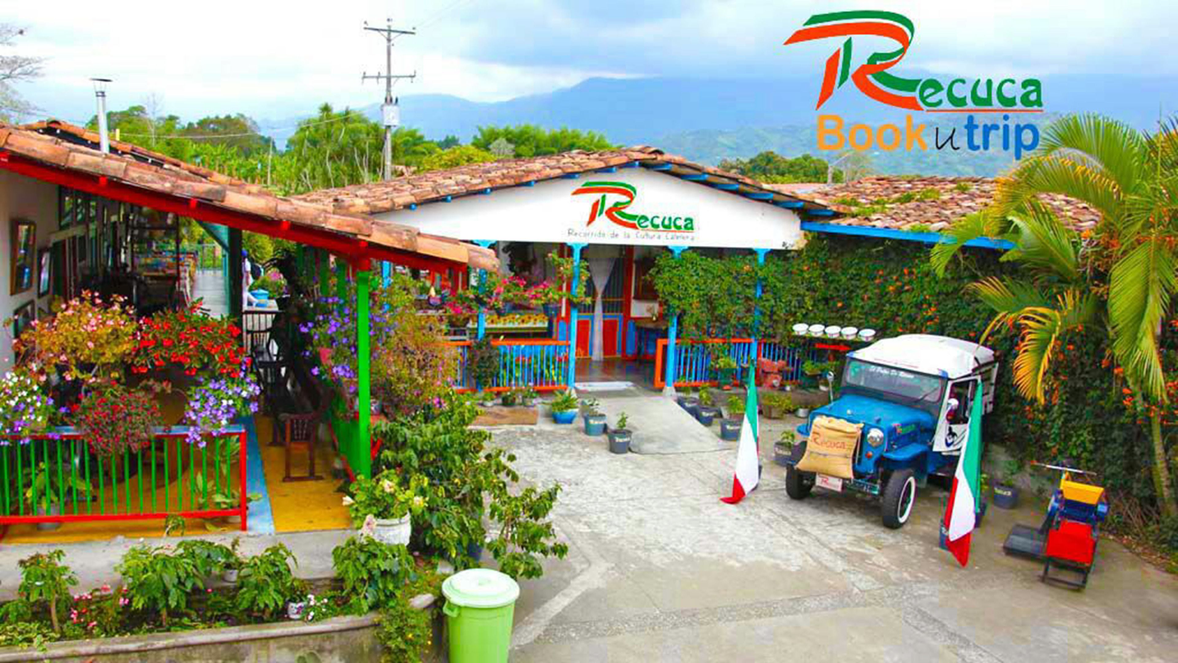 Un edificio colorido con techo de tejas, un vestíbulo cubierto y una camioneta estacionada.