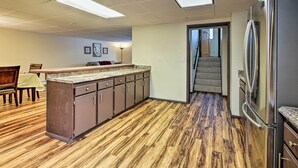 A kitchen with a wooden floor, a refrigerator, and a dining area with chairs and a table. - Lakefront Fairbanks Unit, 1 Mile to Pioneer Park! (Fairbanks)