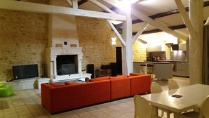 Una sala acogedora con chimenea, un sofá rojo y una mesa de comedor.