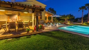 A well-lit outdoor area with a pool, lounge chairs, and a bar area. - Sa Tanqueta Rustica, Country House 5StarsHome Mallorca (Inca)
