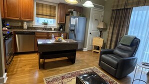 Una cocina moderna con armarios de madera, un refrigerador y un comedor con mesa y sillas.