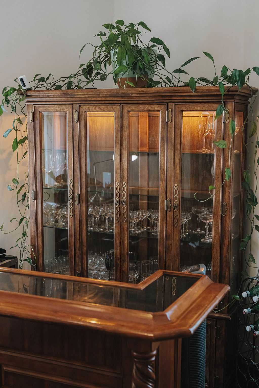 A wooden cabinet with glass doors containing multiple wine glasses.