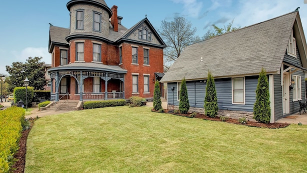 A large, historic house with a prominent turret and a separate wing. - The Baker (North Little Rock)