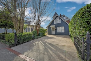 A residential house with a front yard, a paved driveway, and a black metal fence. - The Baker (North Little Rock)
