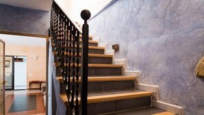 A staircase with wooden steps and black balusters, leading to a room with a view of the outside. - Self catering Can Serrallonga for 15 people (Banyoles)