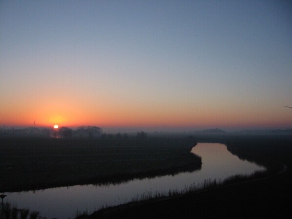 A river at sunset with a clear sky. - Apartment with a sweeping view of beautiful sunsets (Dornumersiel)