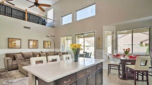 A spacious kitchen with a large island, a dining area with a glass table, and a cozy seating area with a sofa and chairs. - Group Fun in Glendale! Getaway w/ Private Pool (Glendale)