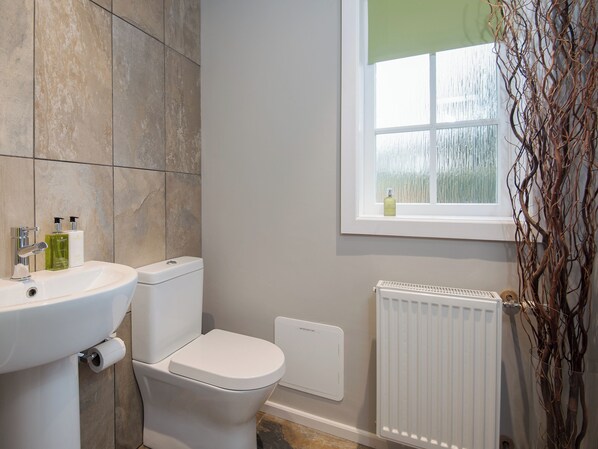 Een badkamer met een witte wastafel, toilet en radiator.
