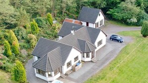 A two-story house with a driveway and a car parked on the side.