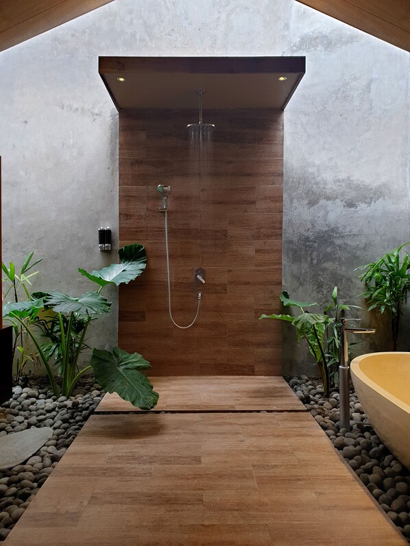 A modern shower area with a wooden panel wall, a handheld showerhead, and a bathtub. - Batatu Resort - Adults Only (Kuta)