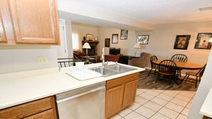 A compact kitchen with a dishwasher, a sink, and wooden cabinets.