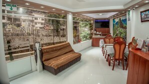 A hotel lobby with a sofa, dining area, and a reception desk. - MAPILAND-Hotel Boutique. a unos pasos de la estación de tren y de autobus. Con vista al río y a las montañas (Machu Picchu)