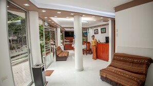 A hotel room with a balcony, a sofa, a desk, and a reception area. - MAPILAND-Hotel Boutique. a unos pasos de la estación de tren y de autobus. Con vista al río y a las montañas (Machu Picchu)