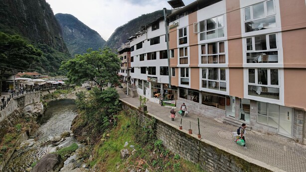 A multi-story hotel with a river running alongside the building. - MAPILAND-Hotel Boutique. a unos pasos de la estación de tren y de autobus. Con vista al río y a las montañas (Machu Picchu)